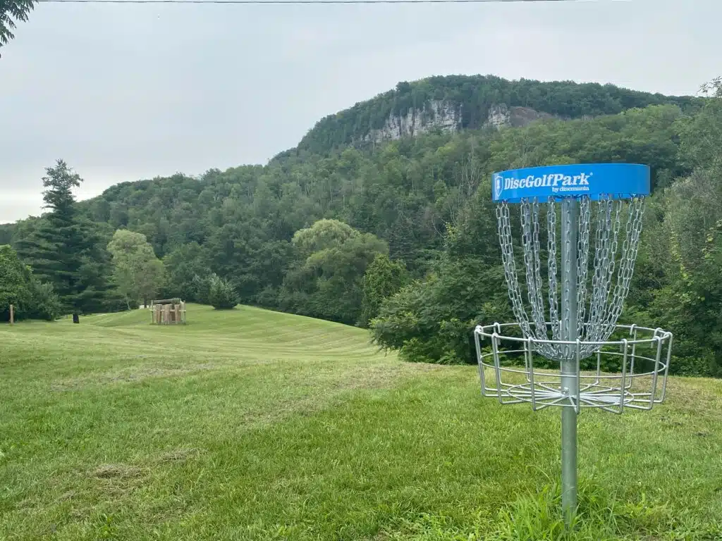 View of the Niagara Escarpment with a disc golf basket in the foreground
