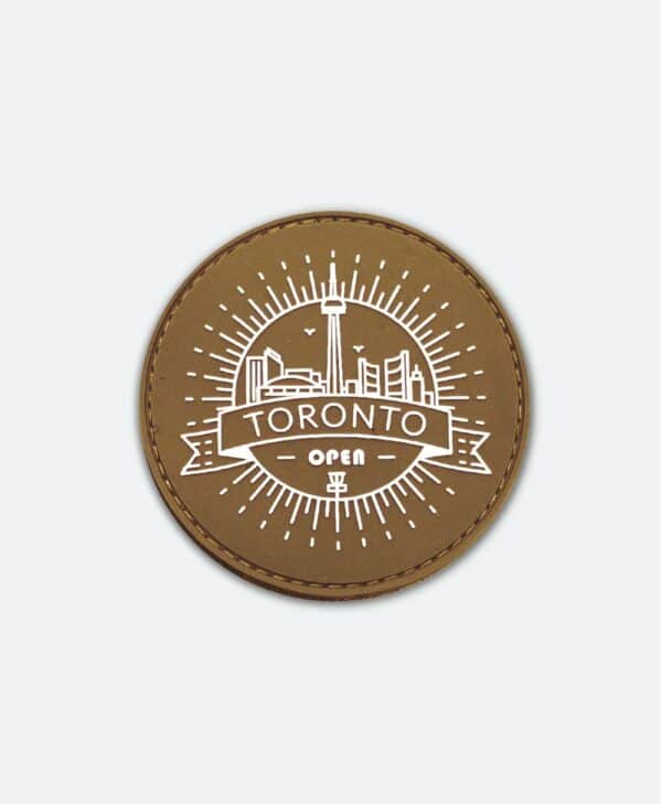 Velcro patch with an off-white TORONTO OPEN logo, set on a sand coloured background.