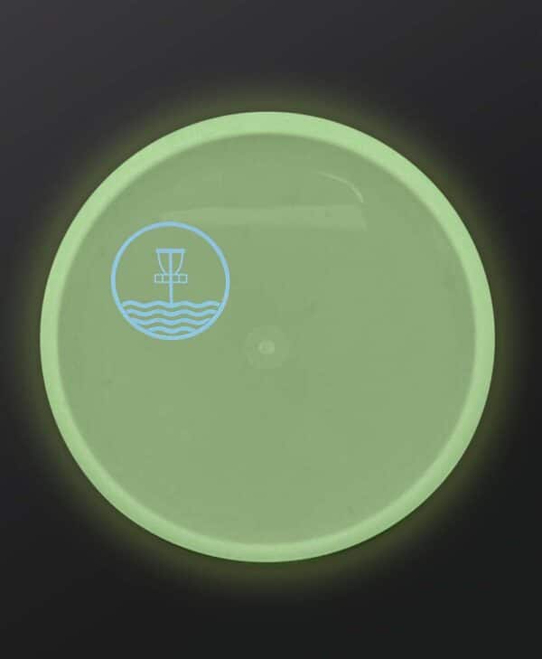Glowing Discmania Shogun with light blue Marilyn Bell Park Disc Golf Course quarter stamp.
