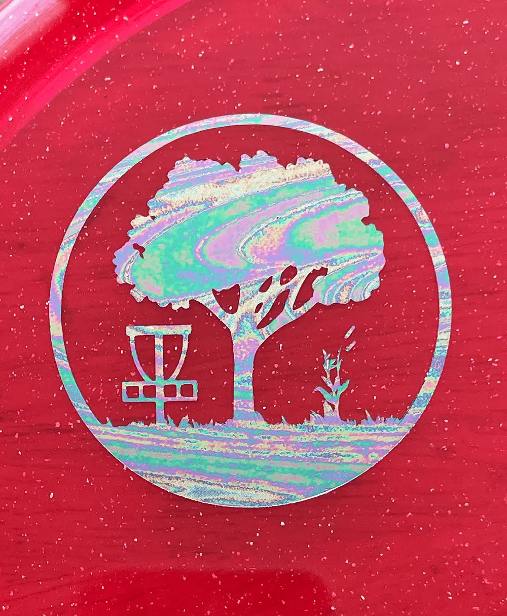 Oil Slick Scarlett Woods Disc Golf Course quarter stamp on a red Metal Flake C-Line MD3.