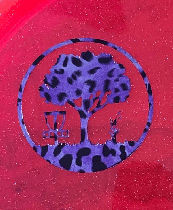 Purple Leopard Scarlett Woods Disc Golf Course quarter stamp on a red Metal Flake C-Line MD3.